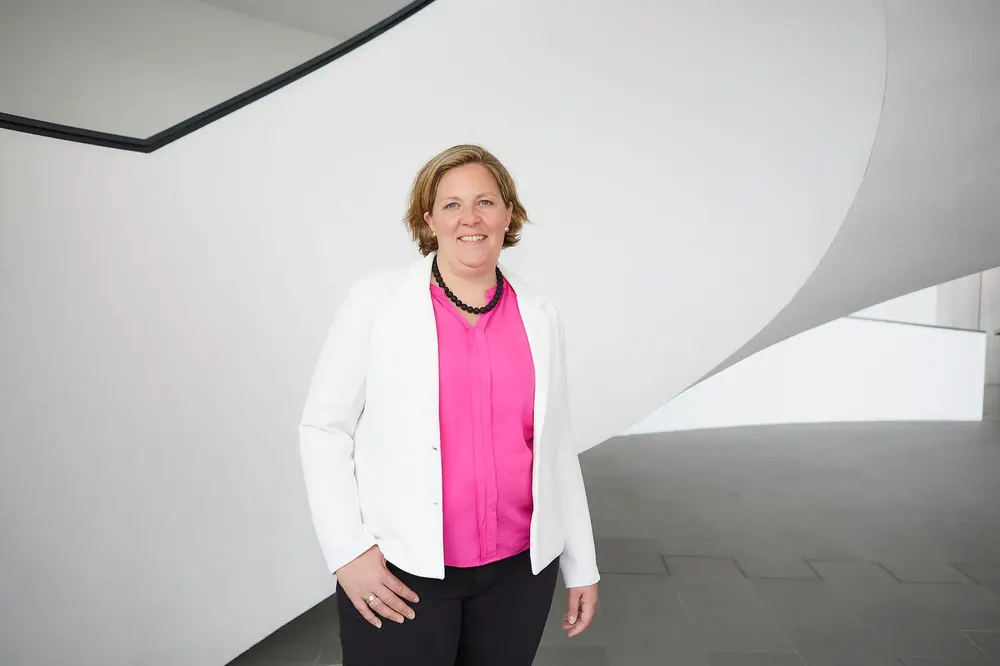 Vera Niermann vor einer weißen geschwungenen Treppe