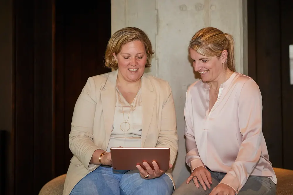 Zwei Frauen betrachten gemeinsam ein Tablet